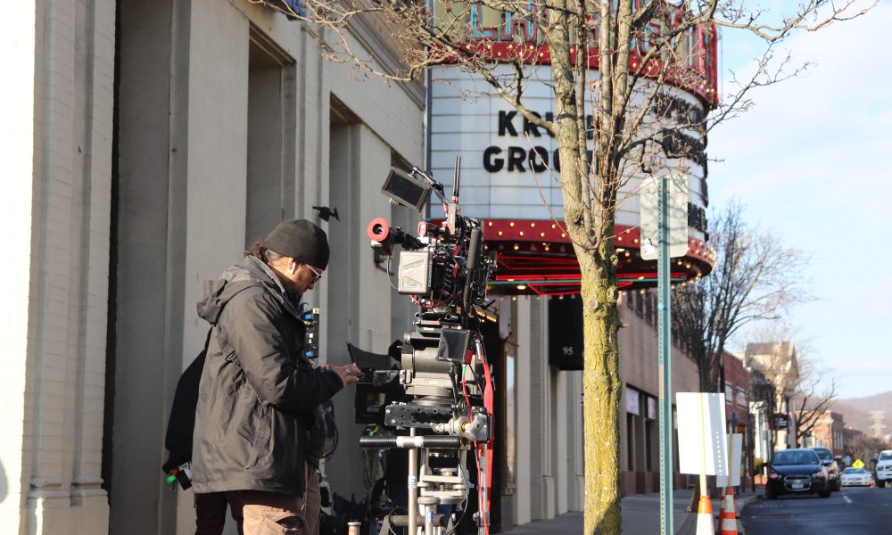 A crew filming near the theater building