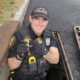 A happy policeman rescuing ducklings